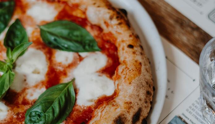 Primo piano di una pizza su un piatto bianco.