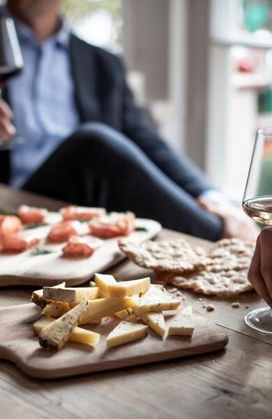 Persone sedute a un tavolo apparecchiato con bicchieri di vino e diversi piatti.
