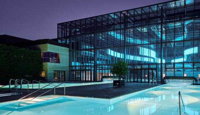 Terme Merano di sera con piscine esterne illuminate.