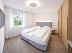 Schlafzimmer im Apartment Gala mit Holzboden, Doppelbett mit gepolstertem Kopfteil, großem Holzschrank, Fernseher und Fenster mit Blick ins Grüne.