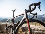 Primo piano di una bicicletta con montagne sullo sfondo.